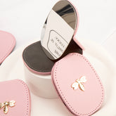 PU Eco-Friendly Leather with Bee Metal Decoration. Stainless Steel Cosmetic Mirror, 80*65mm Oval, Available in White, Pink, Light Pink, and Khaki.