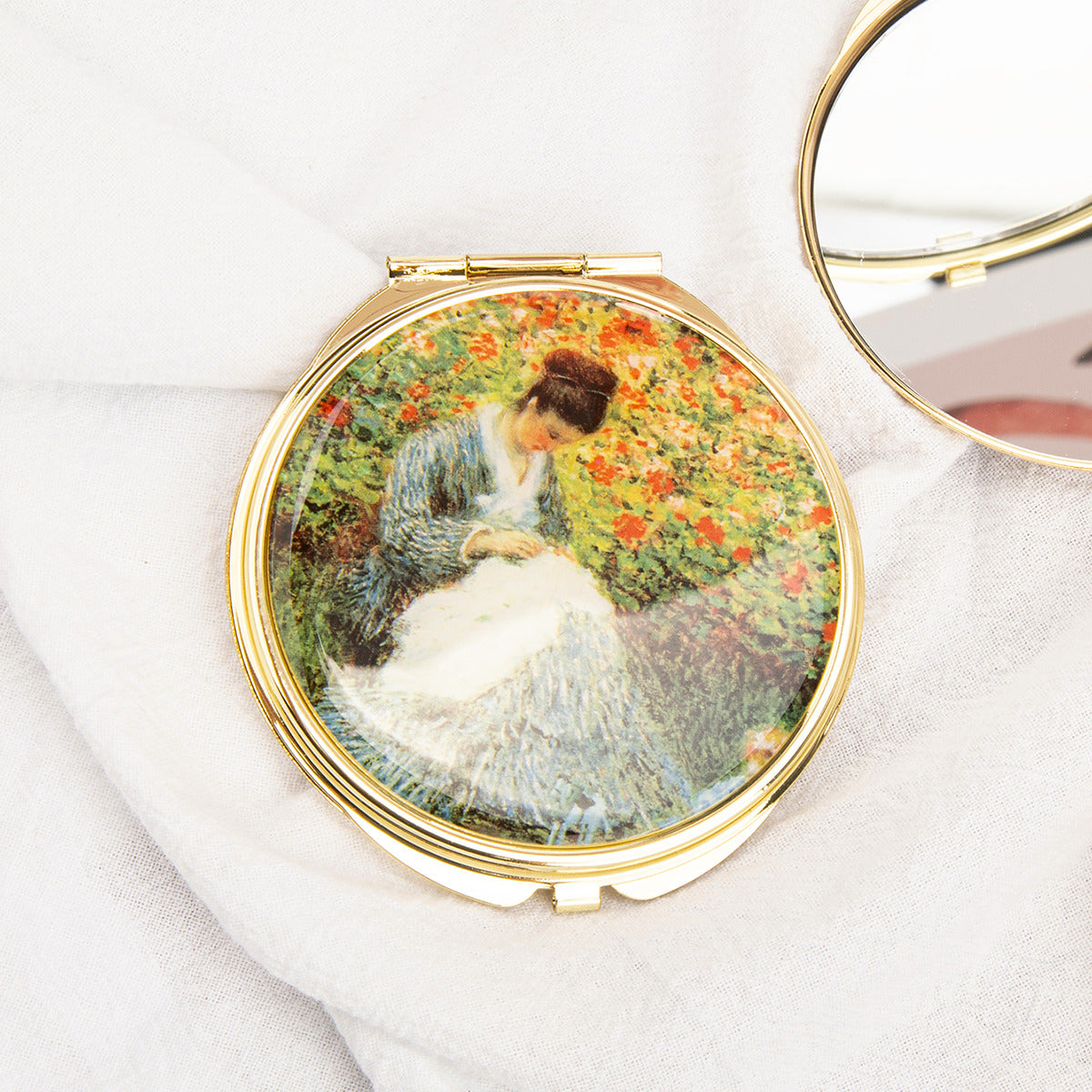 Gold folding compact mirror with woman in garden painting