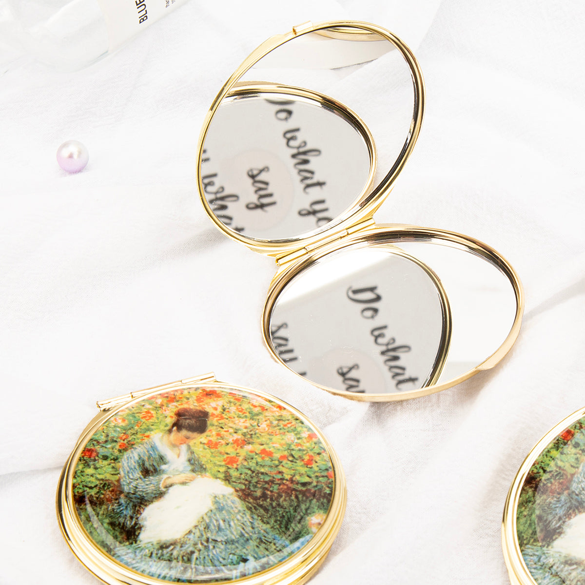 Open gold folding compact mirror showing double mirrors