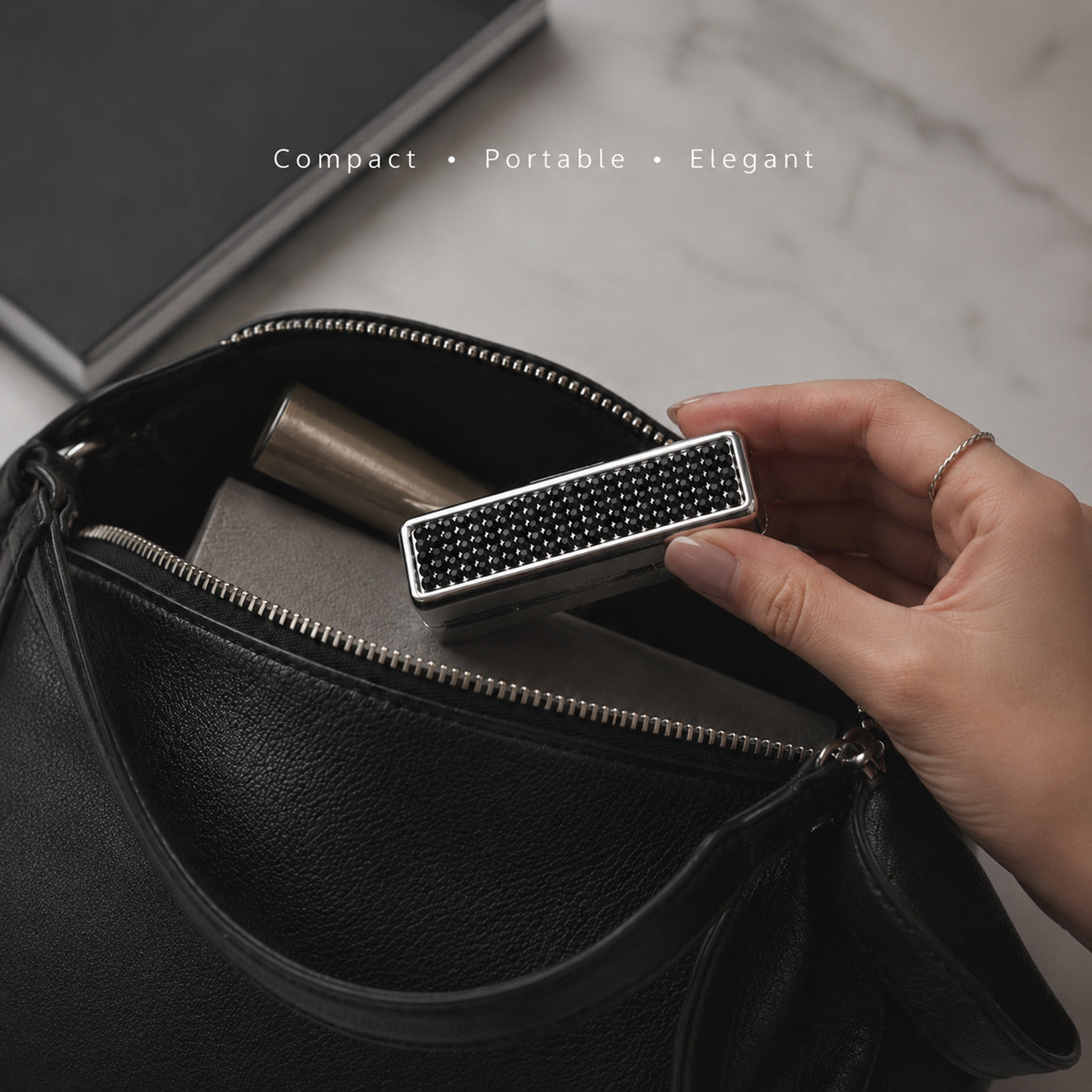 Black rhinestone lipstick case beside a handbag for compact everyday carry