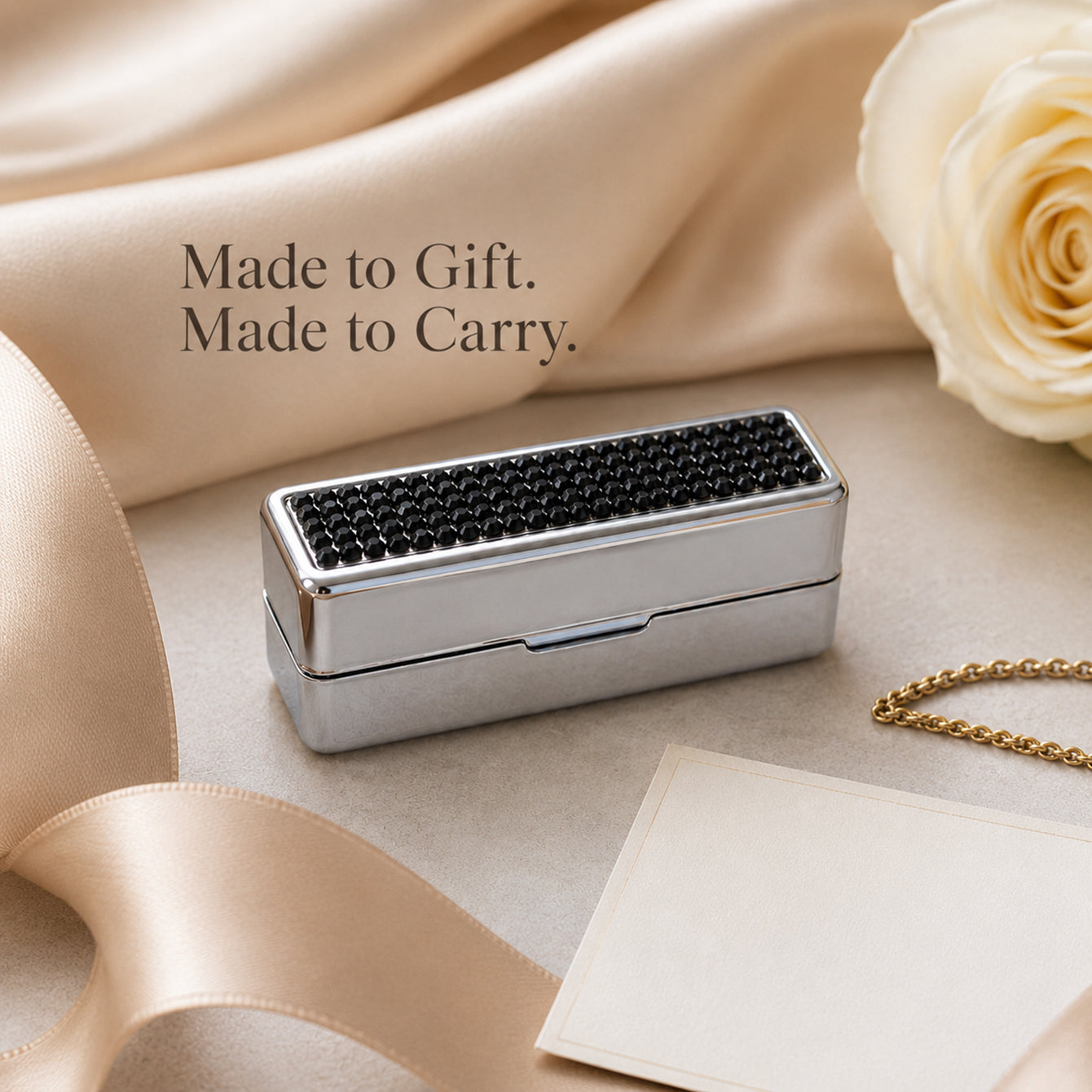 Black rhinestone lipstick case styled as an elegant gift accessory